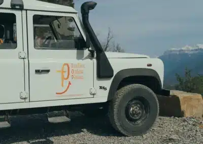 Todoterreno de la Tirolina con tobera del motor y logo, con Monte Perdido al fondo.