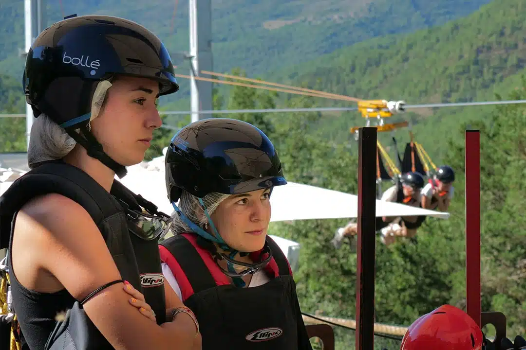 galeria-tirolina-pirineos-ordesa-22- Pareja preparada con arneses y cascos en la plataforma de salida de la tirolina.