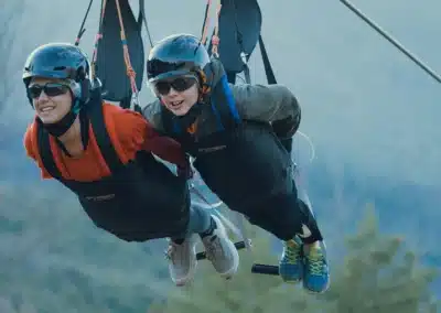 Pareja de adulto y niño disfrutando de un vuelo en la tirolina.