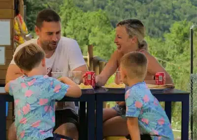 Familia disfrutando de refrescos en la terraza del bar de la Tirolina Pirineos.